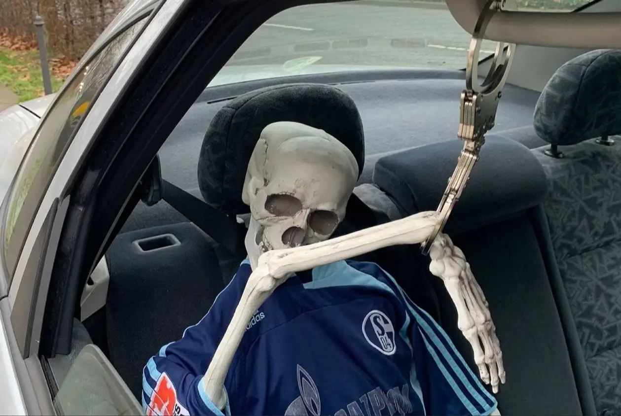 В Германии ездит авто с необычным пассажиром. В салоне сидит скелет в форме «Шальке» – и он пристегнут наручниками