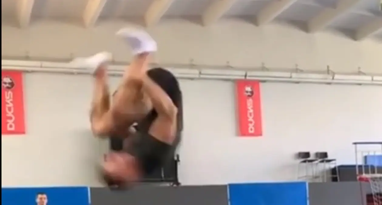 Олимпийский чемпион Александр Абраменко исполняют кульбиты на батуте