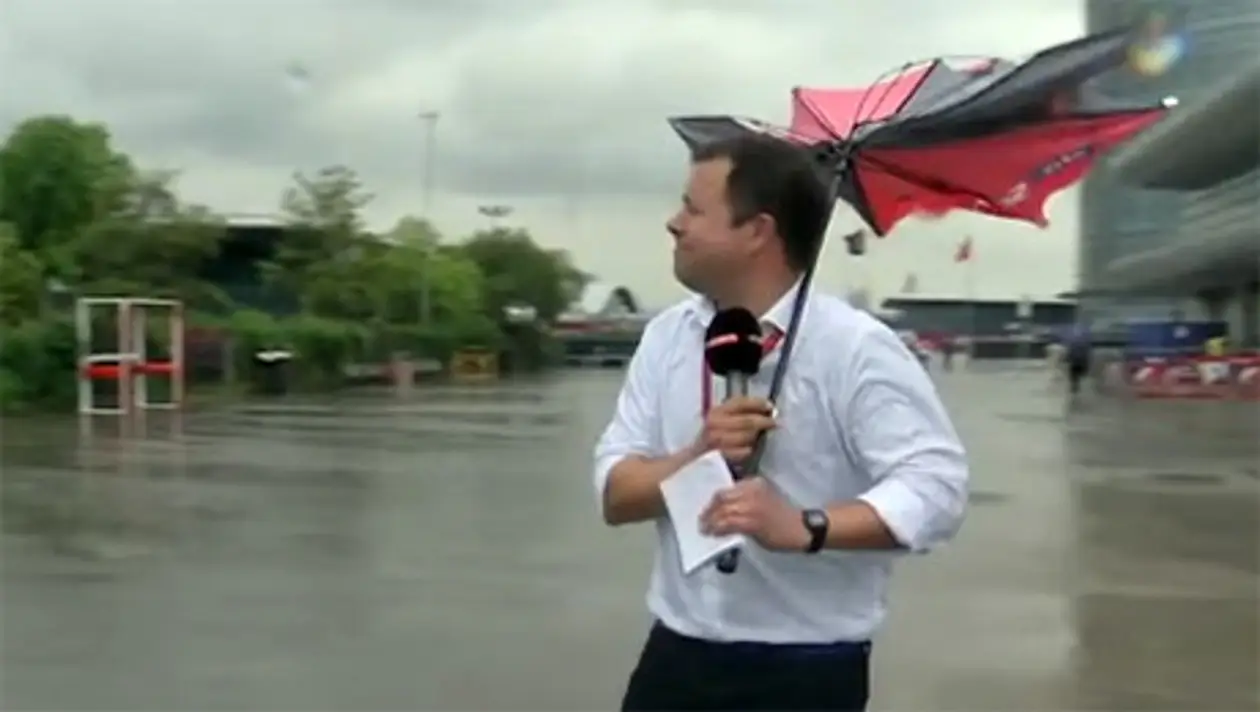 Телевизионный корреспондент борется с зонтиком на Гран-при Китая